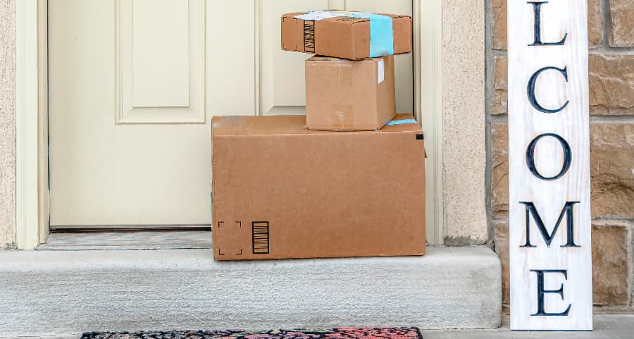 Packages on the doorstep of a home with a welcome sign in Fayetteville